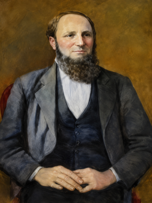 Portrait of a seated James Marshall with a beard wearing a suit and vest against a brown background.